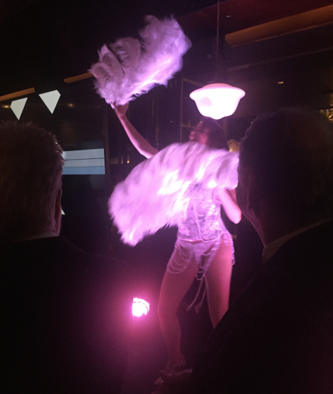 M&C Saatchi founders Tom McFarlane (left) and Tom Dery (right) watch a burlesque dancer at the agency's 21st birthday party
