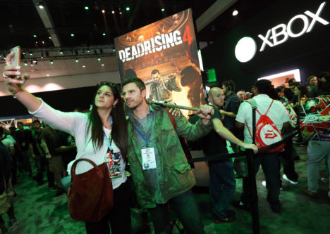 An Xbox fan poses for a photo with Frank West, star of the "Dead Rising" series, at the Xbox booth at E3 2016 in Los Angeles on Tuesday, June 14, 2016. (Photo by Casey Rodgers/Invision for Microsoft/AP Images)