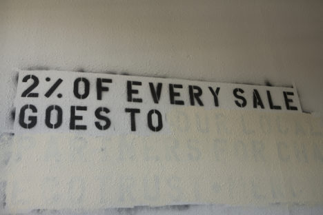 Stencil of 2% of Every Sales Goes To on Abandoned Wall