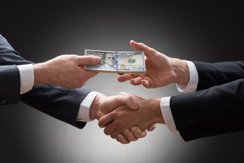 business-men-shaking-hands-with-money-thinkstock